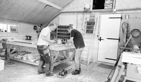 2 mannen aan het werk met de bouw van een houten grafkist